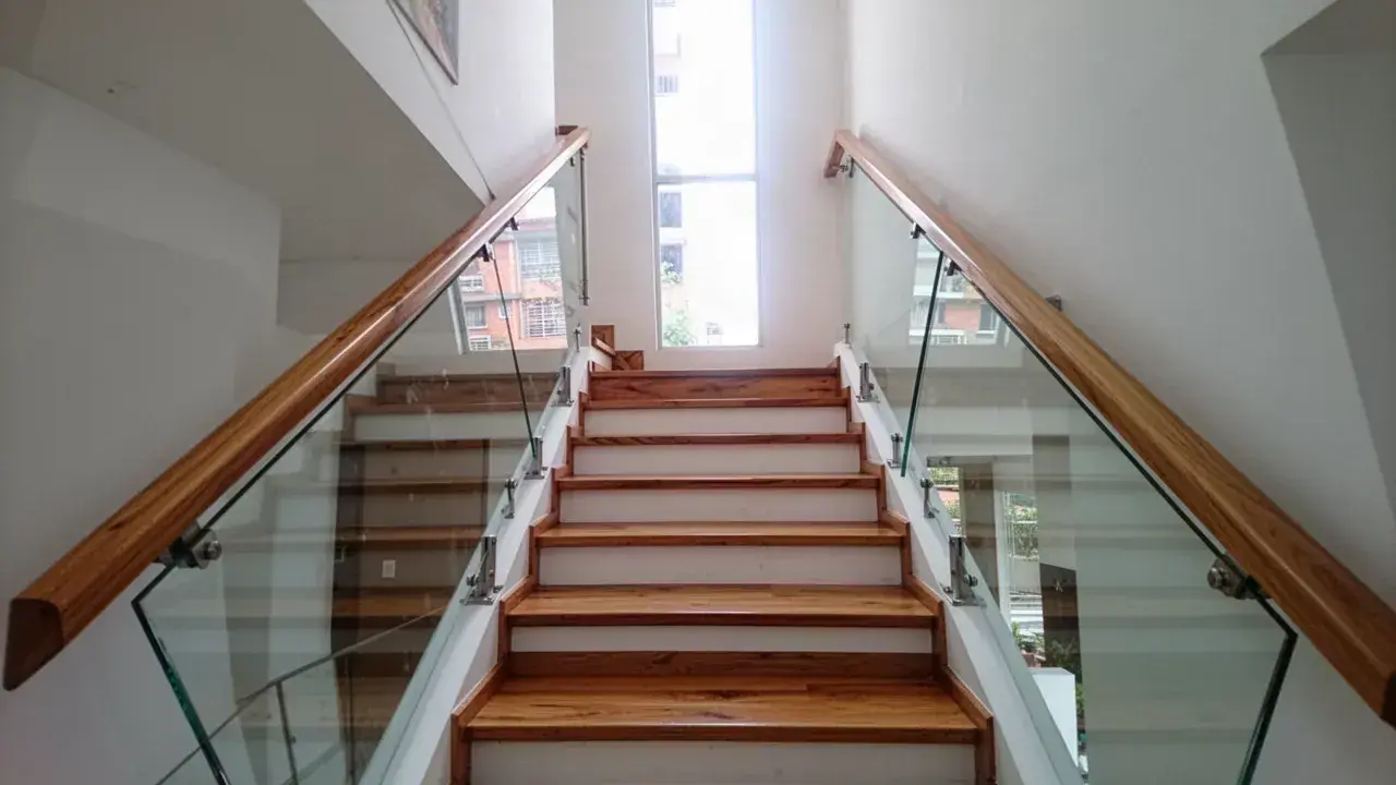 Escalera con huellas de roble y baranda de vidrio