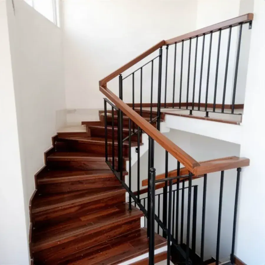 Escalera de madera con baranda metálica negra