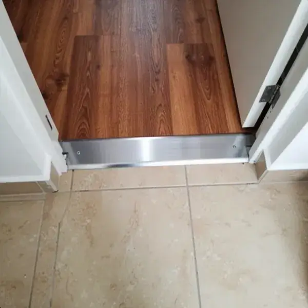 Perfil de transición entre laminado y cerámica en puerta