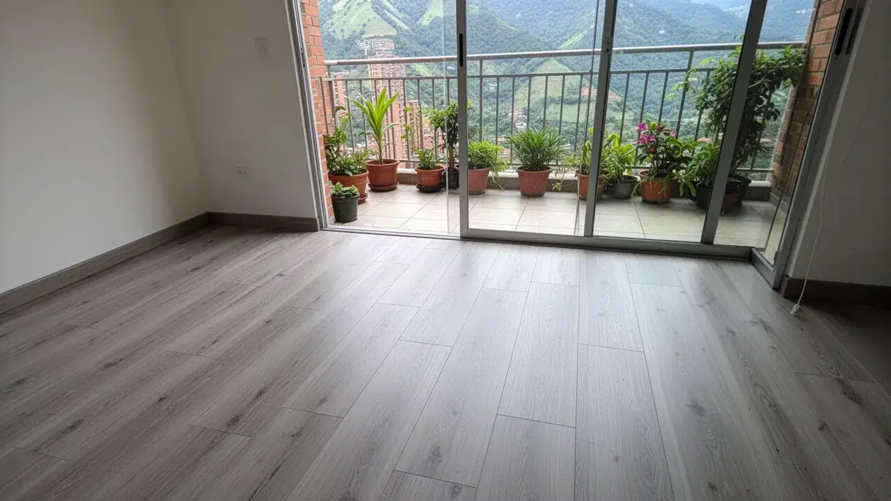 Piso laminado gris con uniones cerradas junto a balcón
