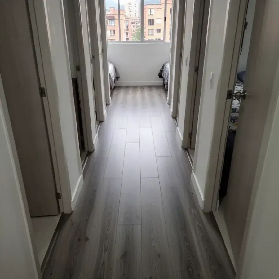Piso laminado gris reparado en pasillo de apartamento