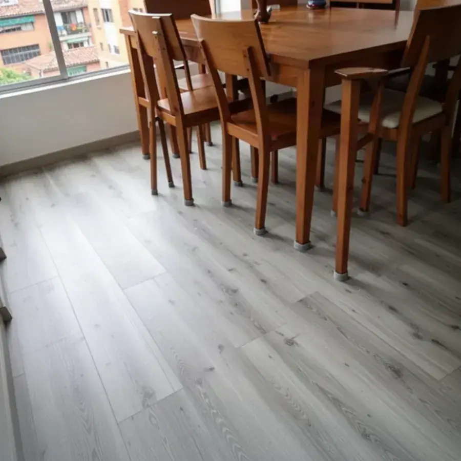 Piso SPC gris claro con protectores bajo sillas