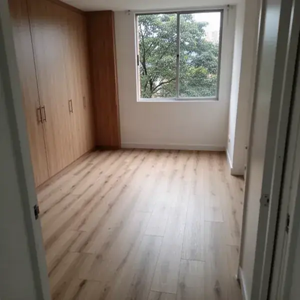 Piso SPC tablón largo en habitación con zócalo blanco