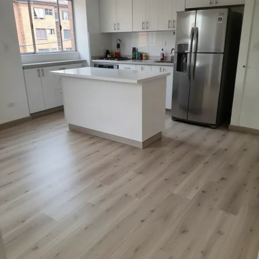 Piso SPC tono fresno con tabla reemplazada en cocina
